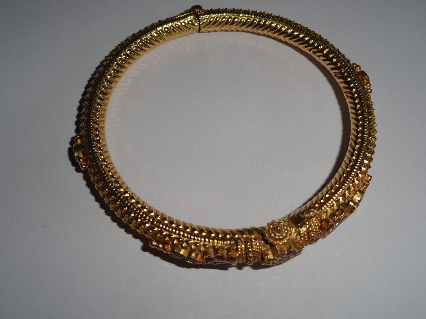 An ornate traditional Indian gold bangle with granulated and twisted wirework