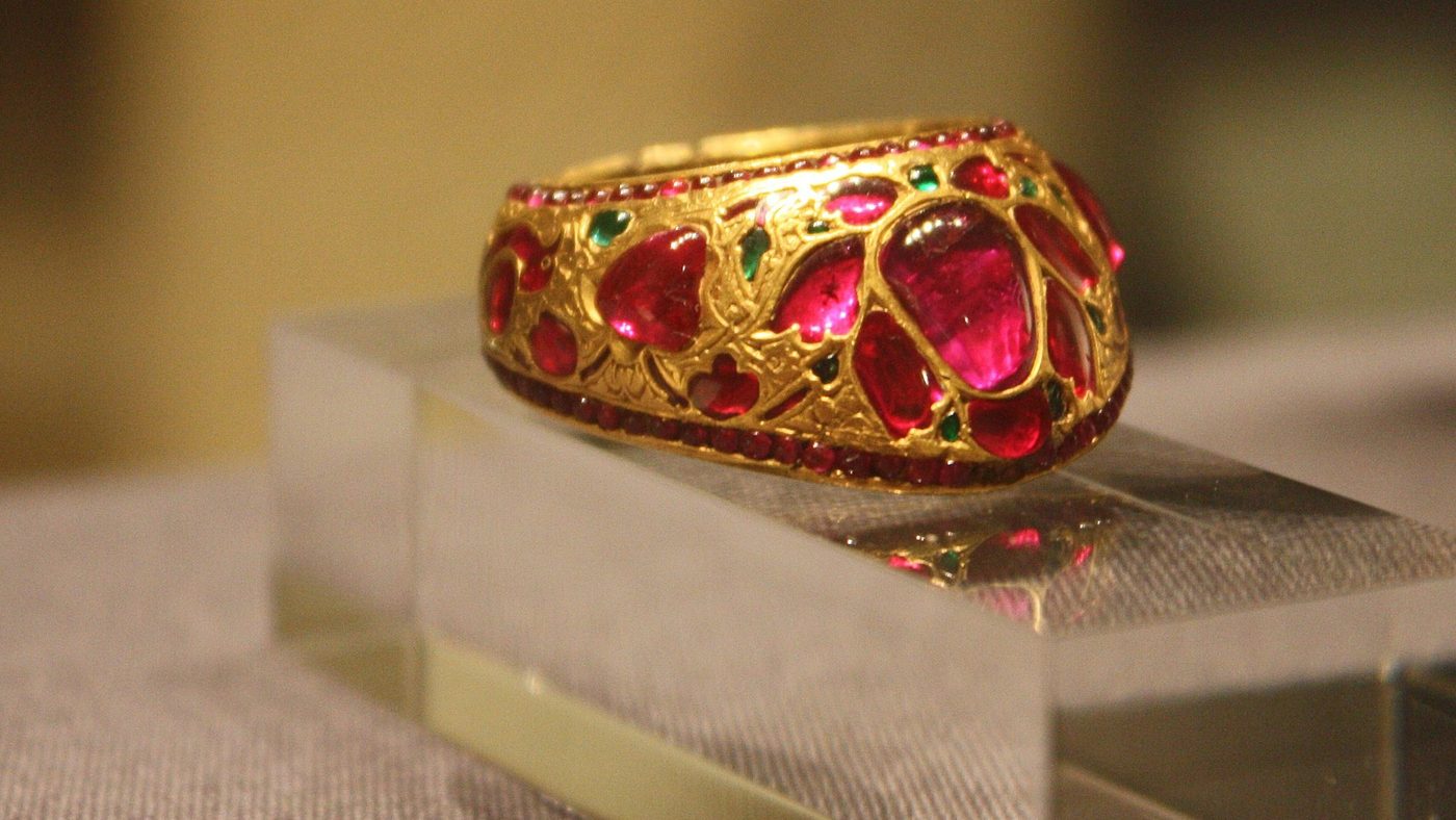 An antique gold thumb ring densely set with rubies and emeralds